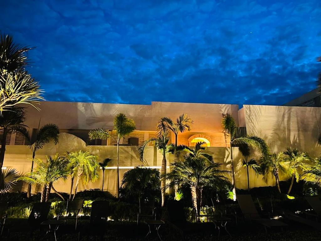 a group of palm trees in front of a building at Casa Begonias Hotel mas Villas in Jiutepec