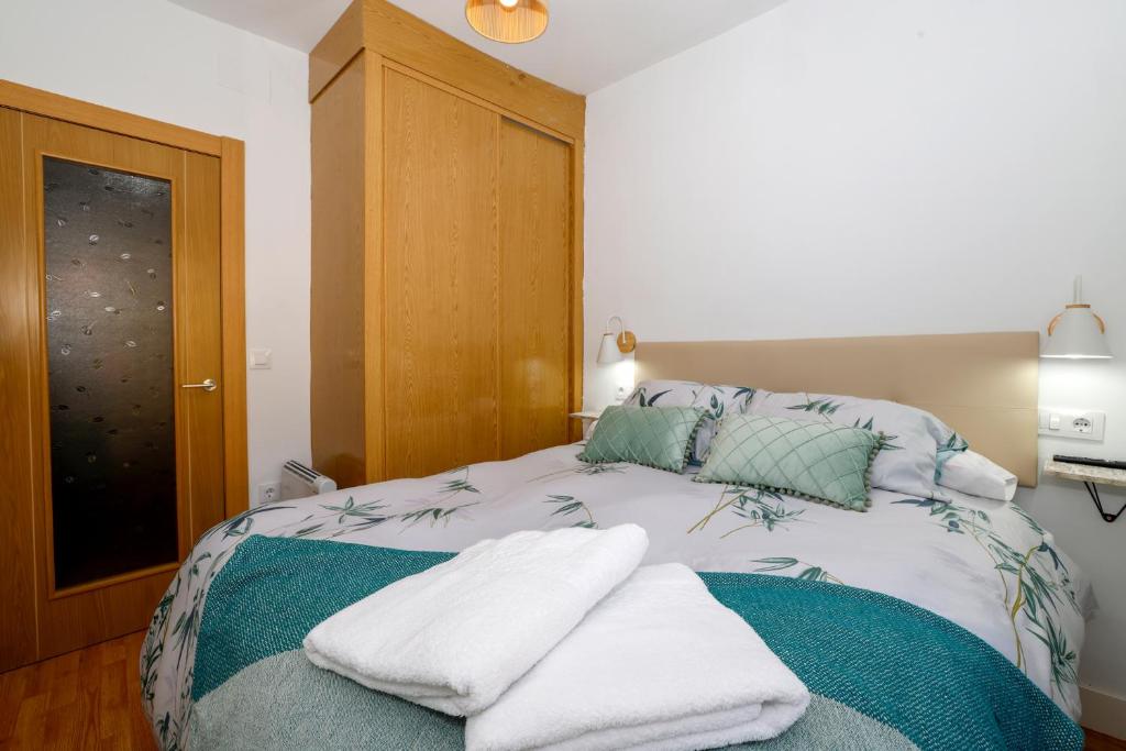 a bedroom with a bed with towels on it at Apartamento San Juan in Riaza