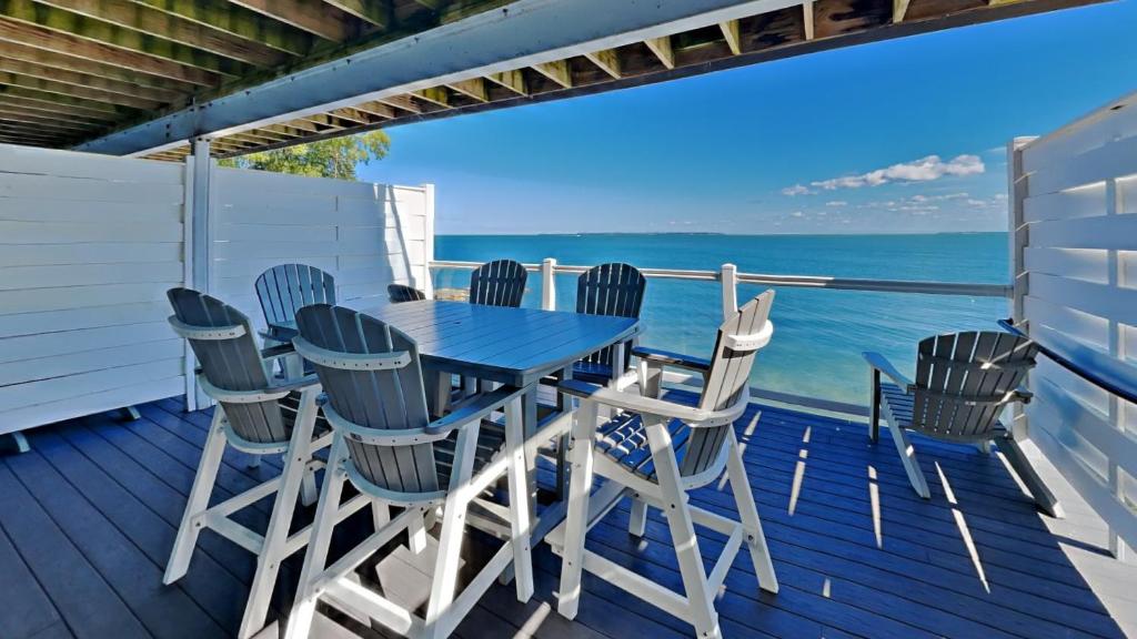a table and chairs on a deck with the ocean at Put-in-Bay Waterfront Condo #109 in Put-in-Bay