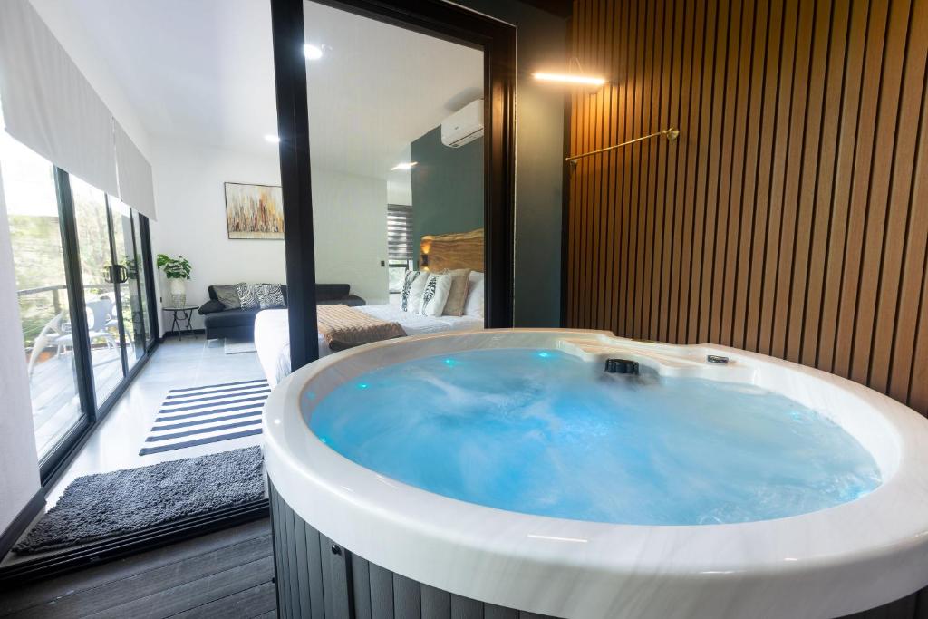 a large bath tub in a room with a bedroom at Casa Violeta Home rentals in Monteverde Costa Rica