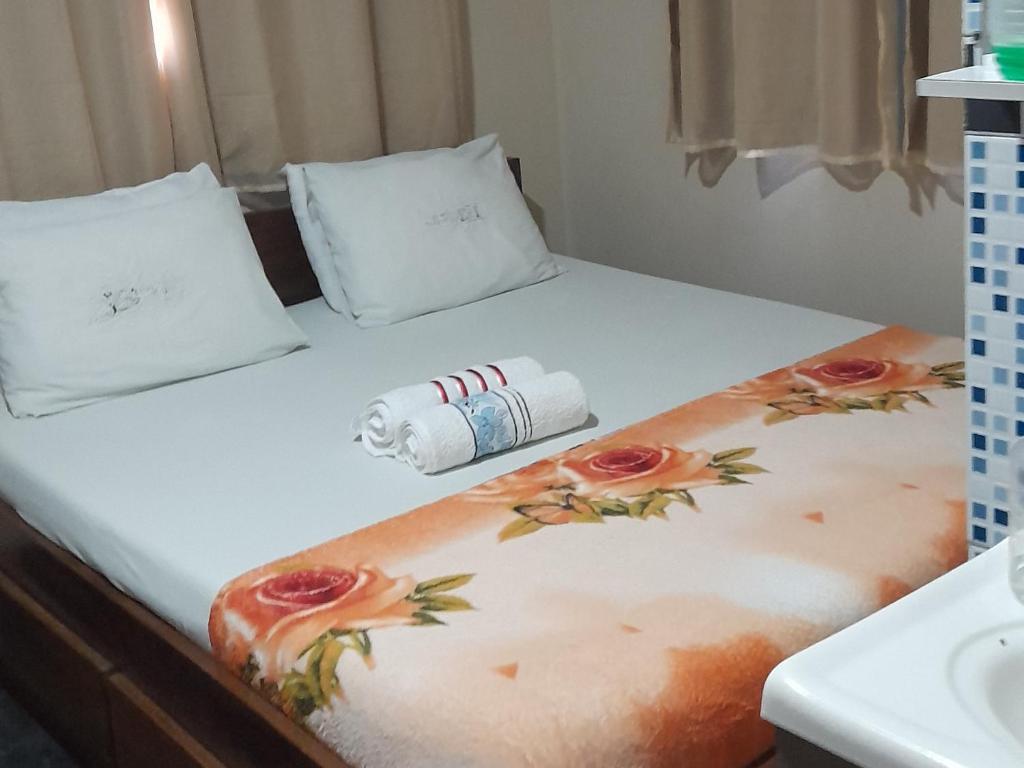 a bed with a roll of toilet paper on it at Pousada Vale Encantado in Serra de São Bento