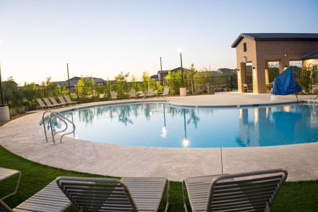 a large swimming pool with chairs around it at Spacious 3BR Home - Pool, Playground, EV Station L2, Near Freeway, Free Parking in Tucson