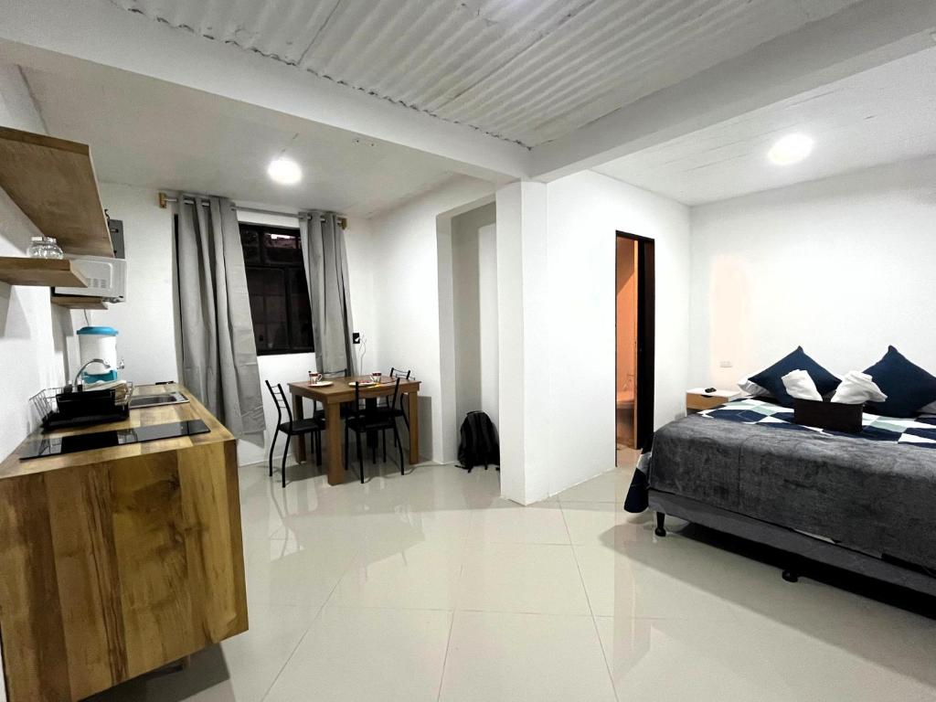 a bedroom with a bed and a kitchen with a table at Casa Magdalena N1 in San Pedro La Laguna