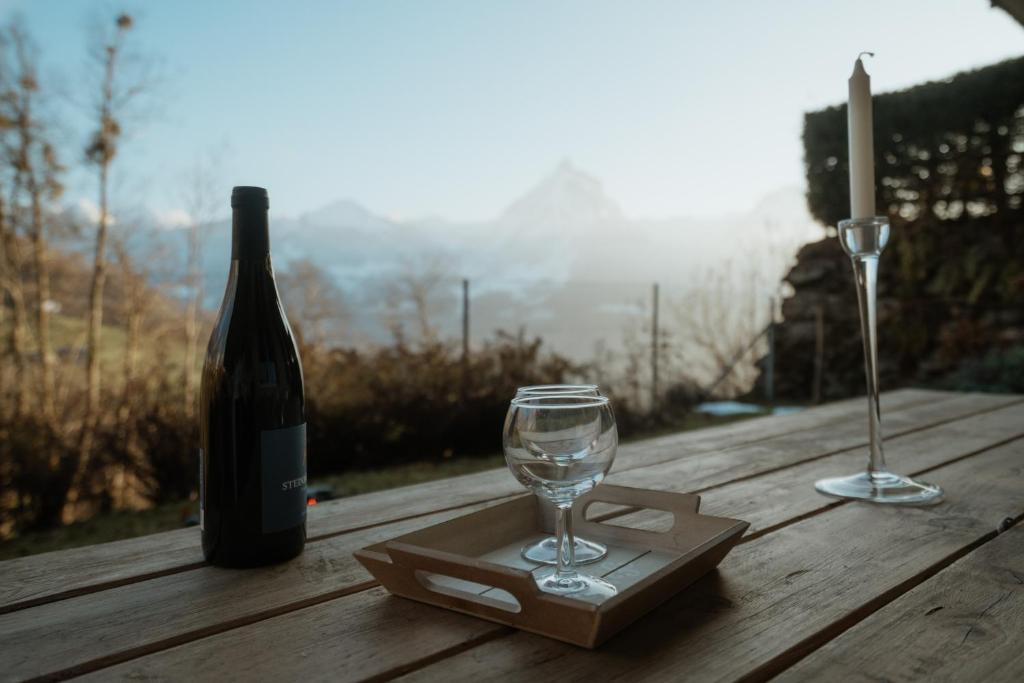 a bottle of wine and a glass on a wooden table at Apartment Bergzauber in Amden