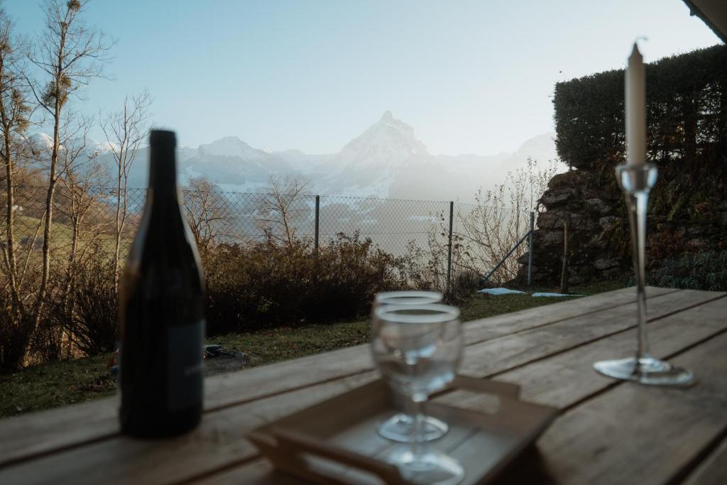a bottle of wine sitting on a wooden table with a glass at Apartment Bergzauber in Amden