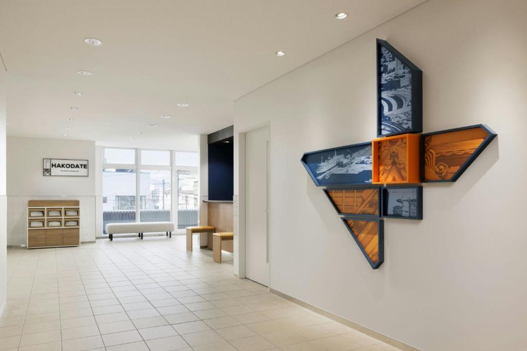 a room with a wall with paintings on it at Four Points Flex by Sheraton Hakodate Station in Hakodate