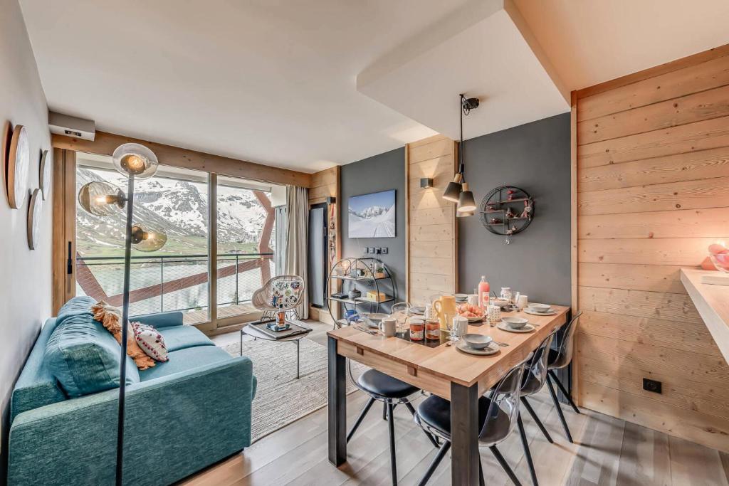 une salle à manger avec une table et un canapé bleu dans l'établissement Résidence Phoenix - 3 Pièces pour 4 Personnes MAE-0401, à Tignes