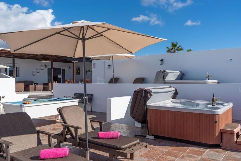 patio con vasca idromassaggio e ombrellone di Apartment Geranio - Rural Guest Apartment a Tías