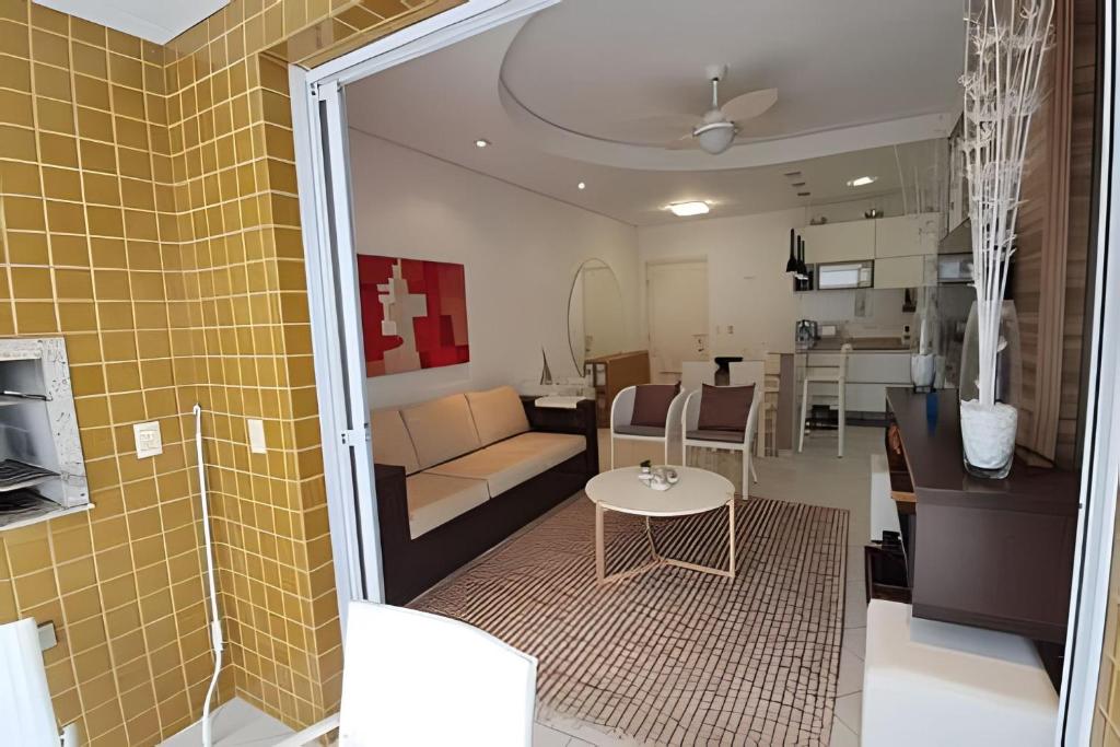 a living room and kitchen with a couch and a table at Ap Completo /Ar e Wi-Fi/ Riviera in Riviera de São Lourenço