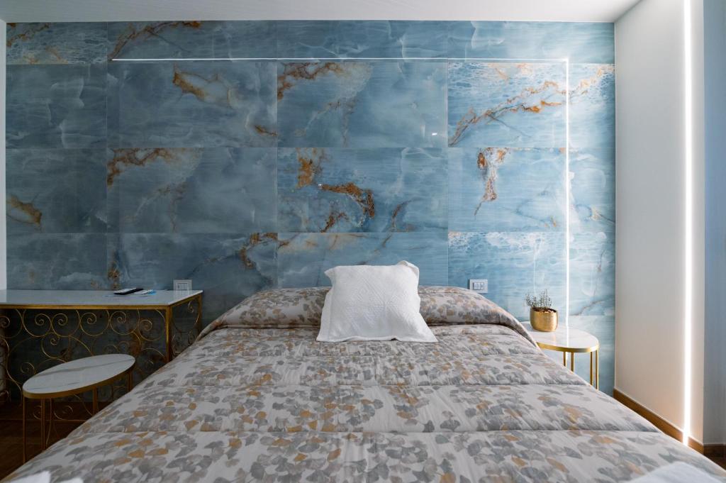 a bedroom with a bed with a blue wall at RosAmar in Bari