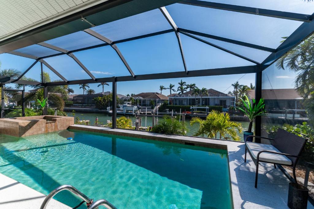 マルコ・アイランドにある"The Lighthouse" l Gorgeous Waterfront 3 Bed with Quick Access to Gulfの水面が見えるガラス屋根付きのプール