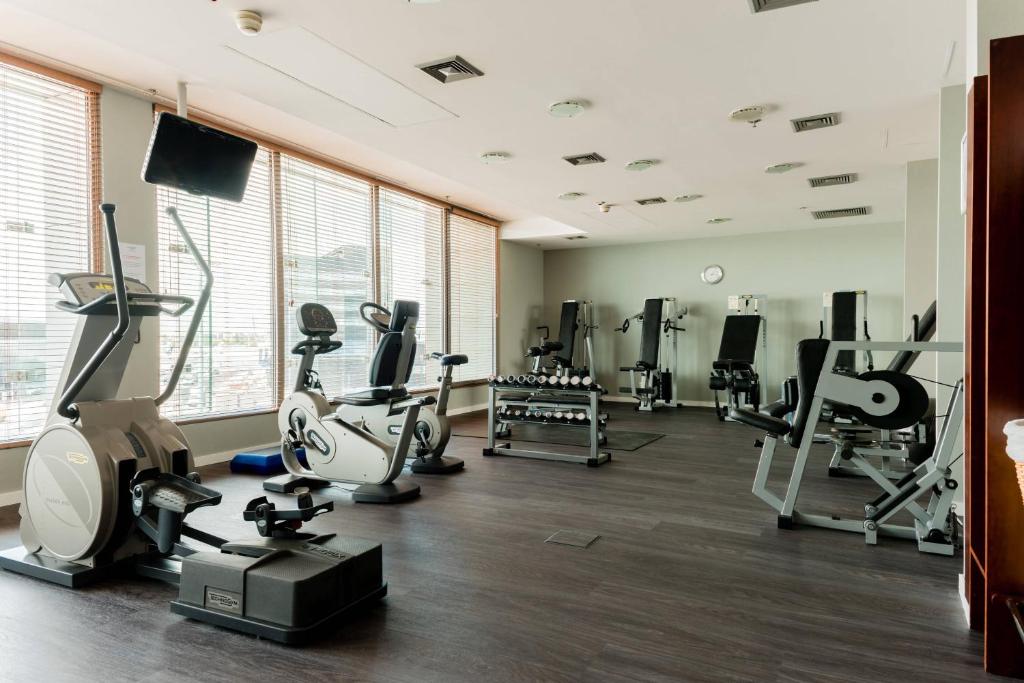 a gym with several treadmills and machines in a room at Courtyard by Marriott Warsaw Airport in Warsaw