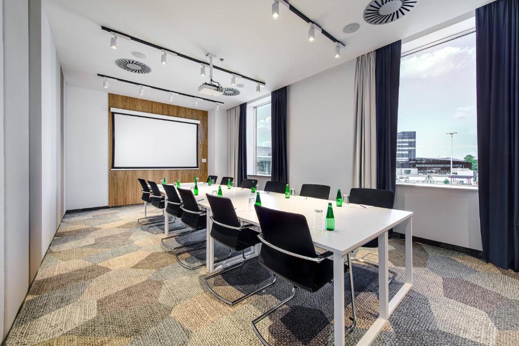 a conference room with a long table and chairs at Courtyard by Marriott Warsaw Airport in Warsaw