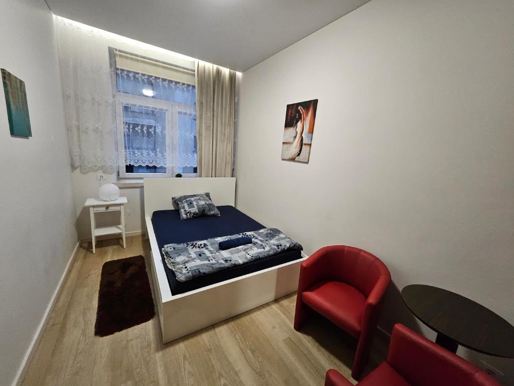 a small bedroom with a bed and a chair at Kauno apartamentai big bed in Kaunas
