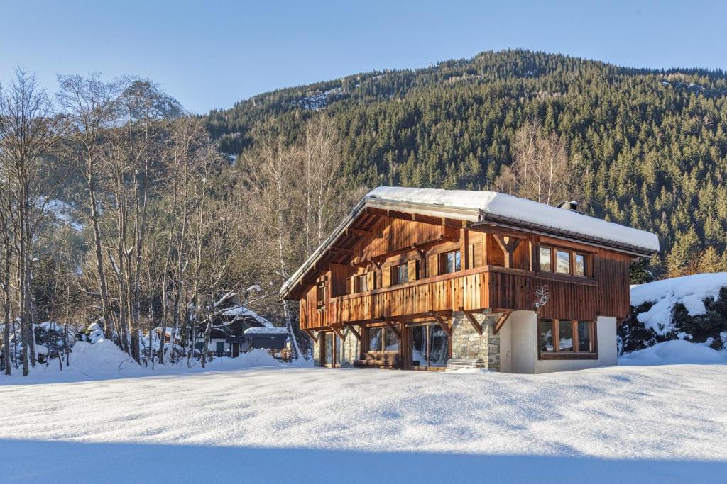 une cabane en rondins dans la neige avec une montagne dans l'établissement Chalet du Golf 618 - Happy Rentals, à Chamonix-Mont-Blanc