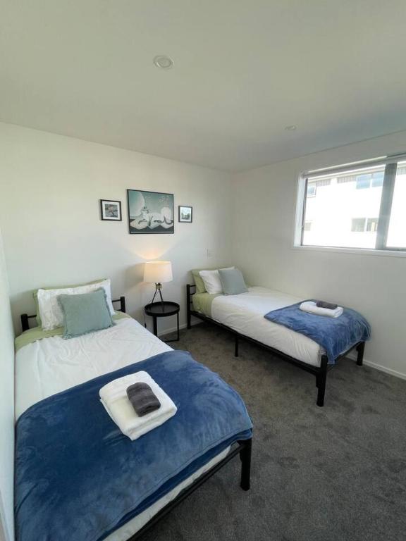 une chambre avec deux lits et une fenêtre dans l'établissement Mohua Lane Urban Paradise, à Christchurch