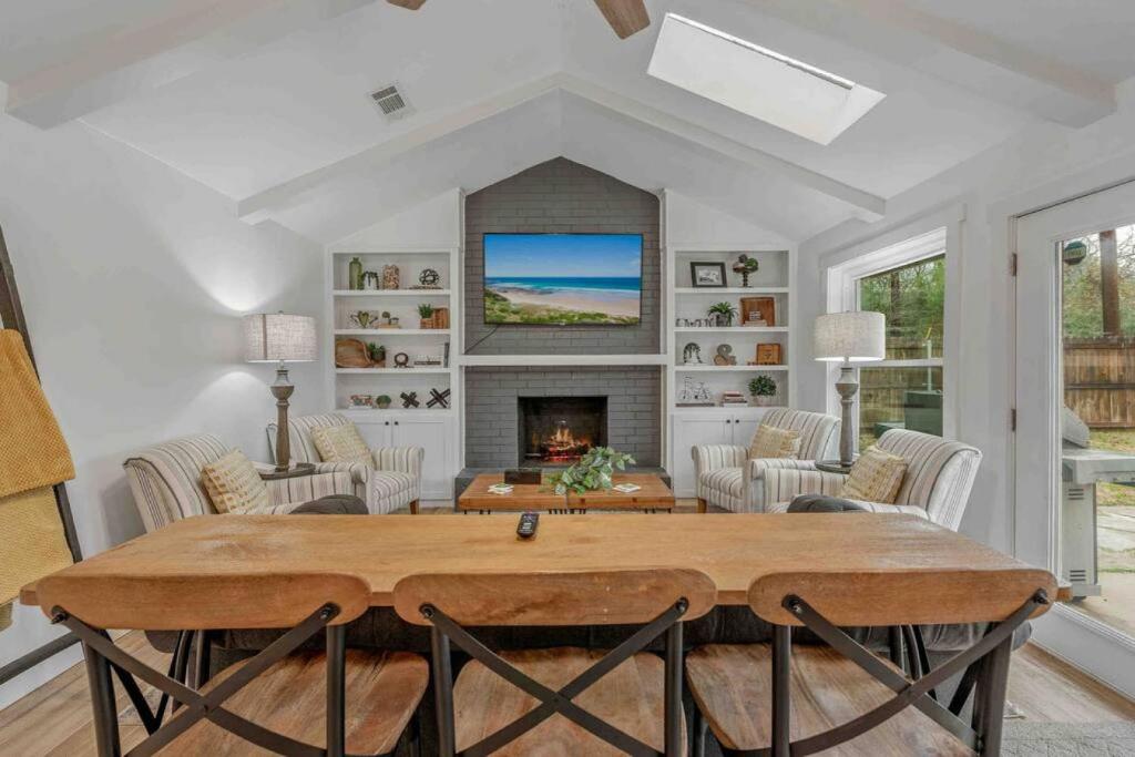 Una sala de estar con una mesa y una chimenea. en Heated Pool Relaxing Casa da Vida 4 BR 3BA Pet Friendly, en Bryan