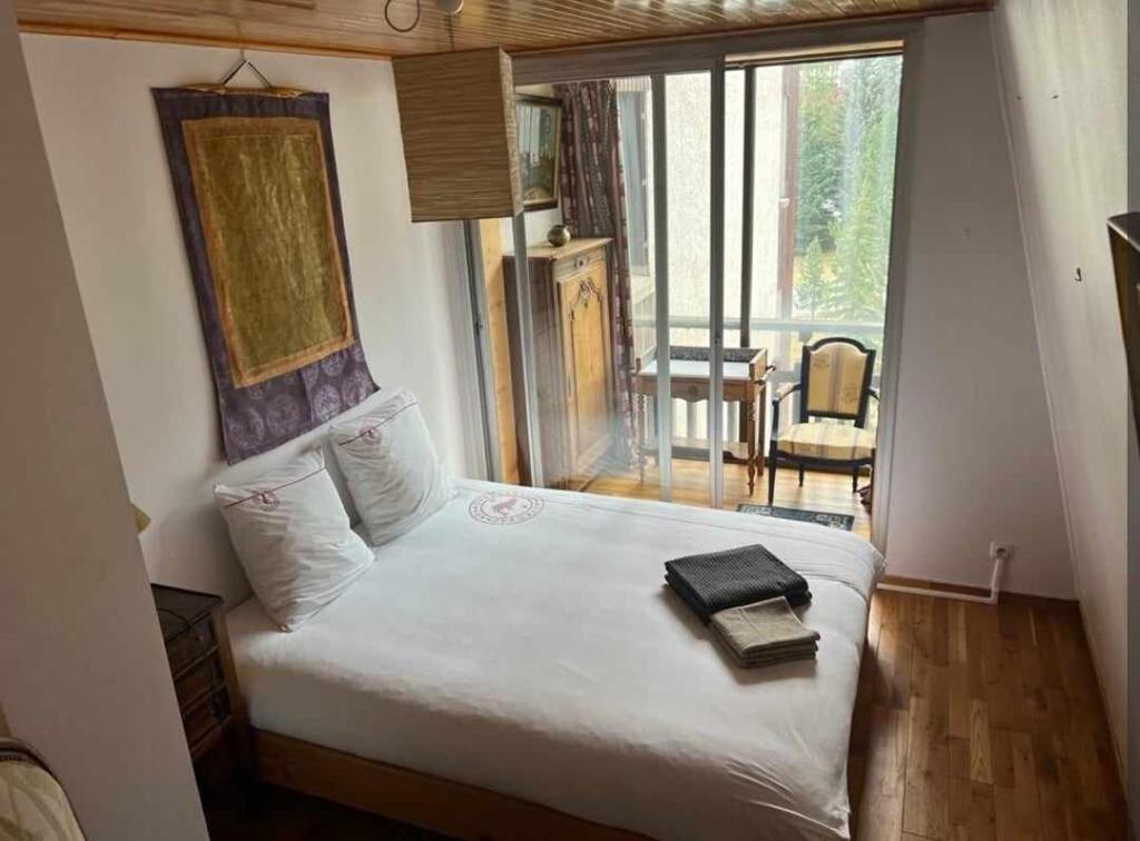 a bedroom with a bed with a book on it at Grand appartement 4 pers, face aux pistes in La Salle Les Alpes