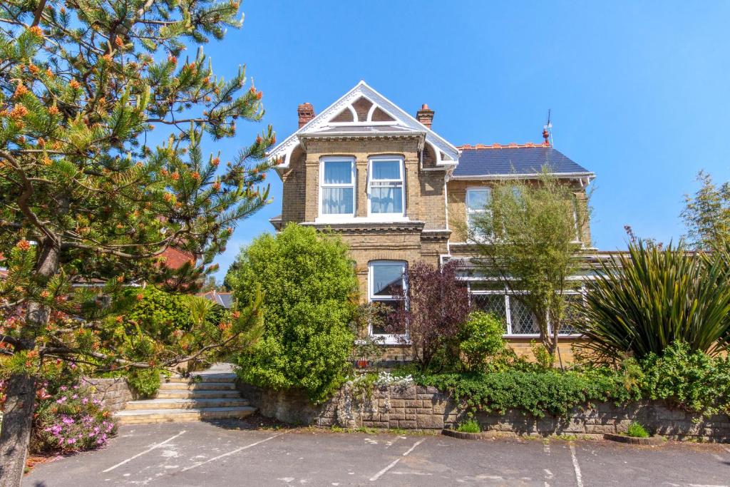 an old house with a stone wall and trees at Isle of Yoga Garden Flat in Shanklin