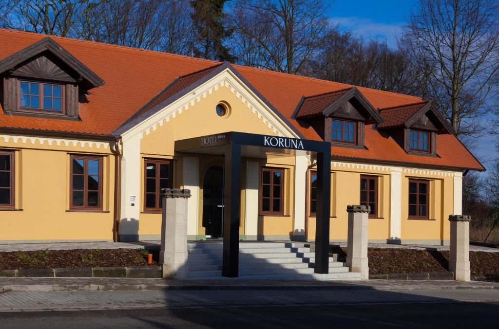 a yellow building with an orange roof at Hotel Koruna in Chlumec nad Cidlinou