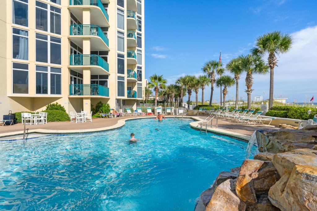 a swimming pool at a resort with palm trees at Jade East Towers 0630 by Newman-Dailey in Destin