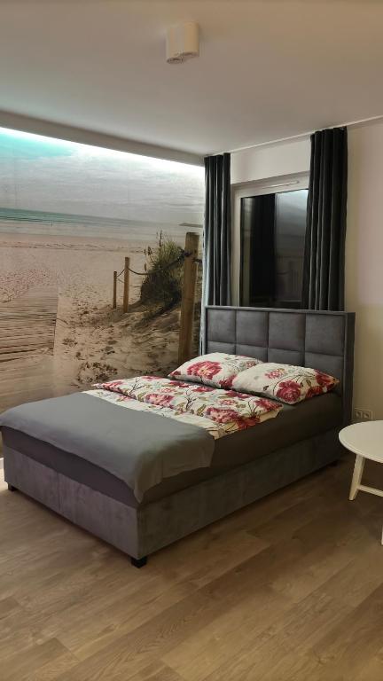 a bedroom with a bed with a view of the beach at Apartament Pogodny in Chojnice