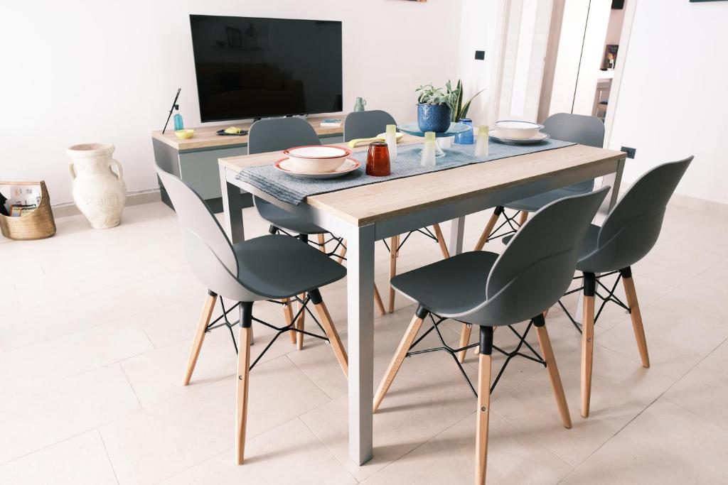 a dining room table with chairs and a television at Domus Urbana - Guest House in Pompei