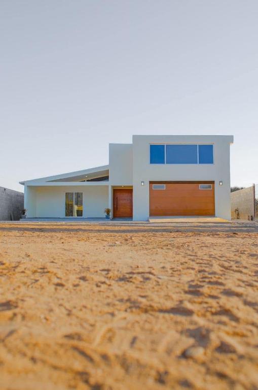 a house with two garage doors in the middle of a field at CASA LUGO mx in El Porvenir