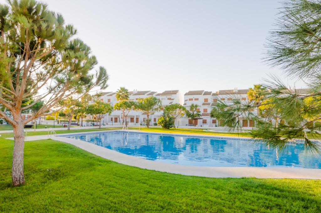 una piscina en un parque con árboles y edificios en Maracaibo, en Chiclana de la Frontera