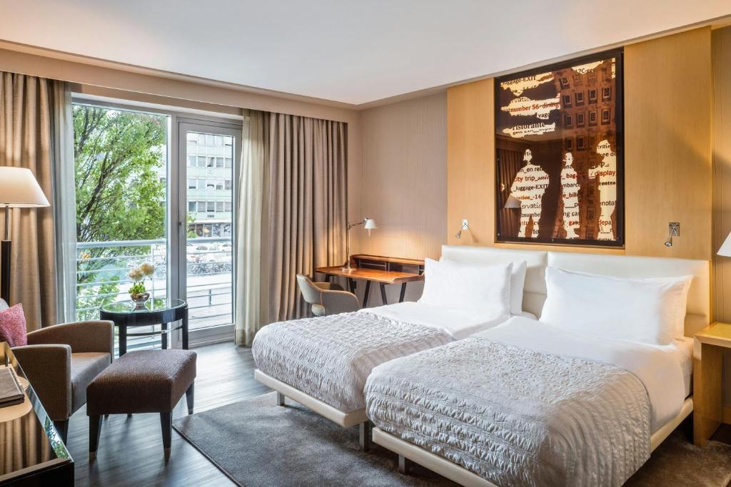 a hotel room with a bed and a desk at Le Méridien Munich in Munich