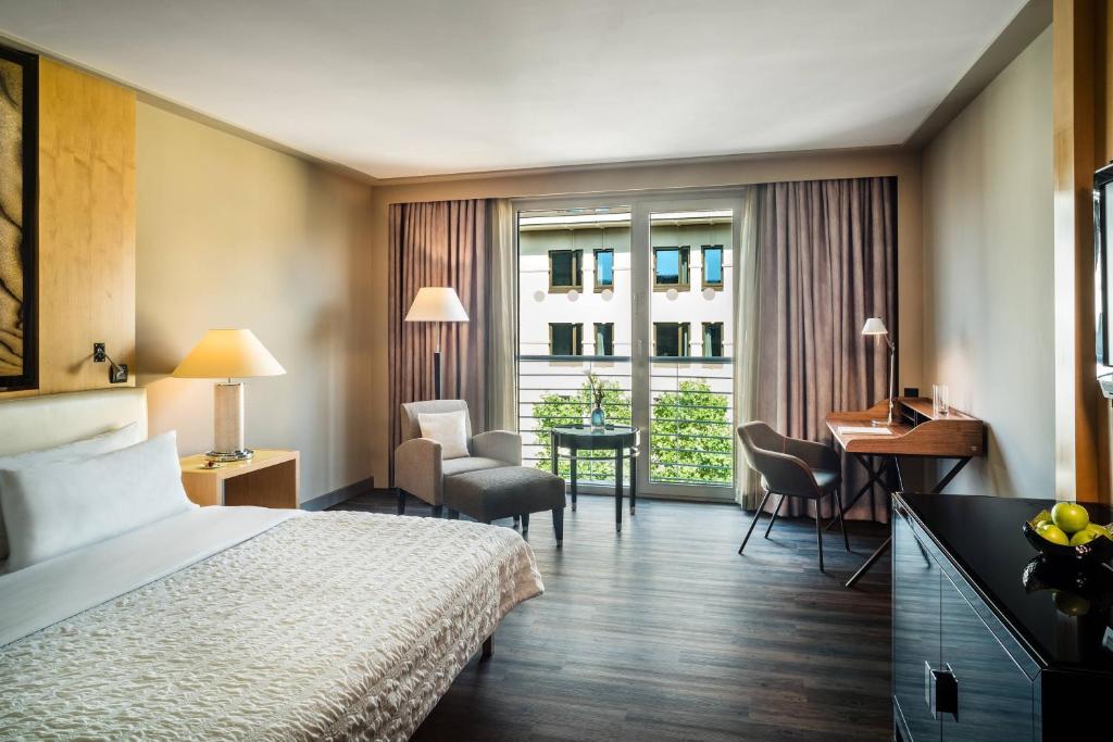 a hotel room with a bed and a desk at Le Méridien Munich in Munich
