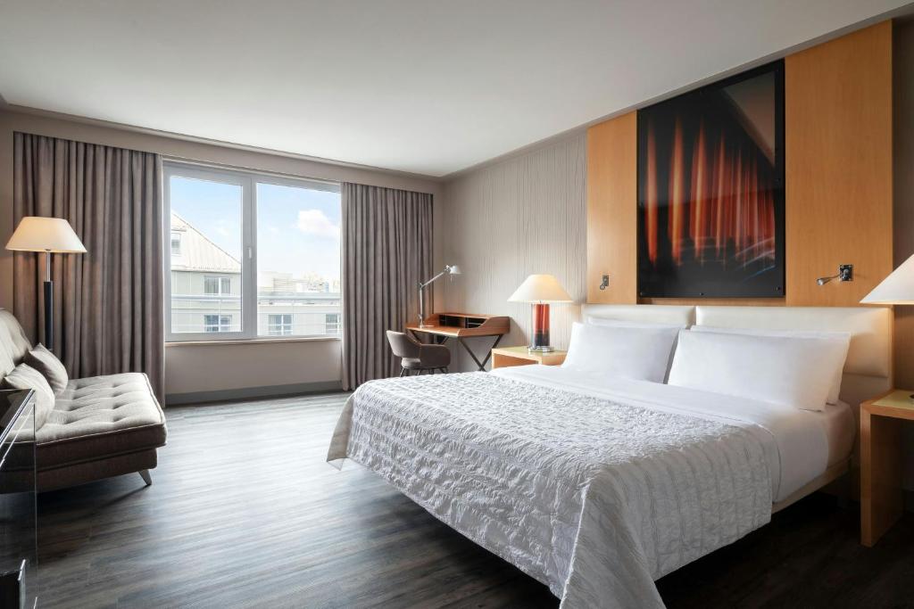 a hotel room with a large bed and a desk at Le Méridien Munich in Munich