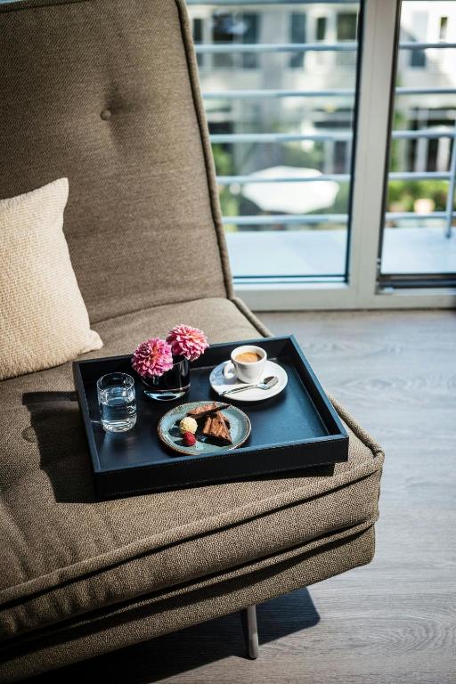 a tray with food and a cup of coffee on a chair at Le Méridien Munich in Munich