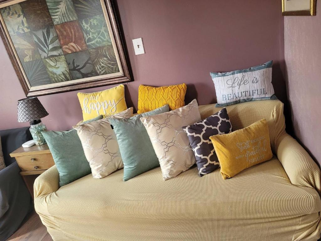 a couch with colorful pillows on it in a room at Tower Of Little Italy in Niagara Falls