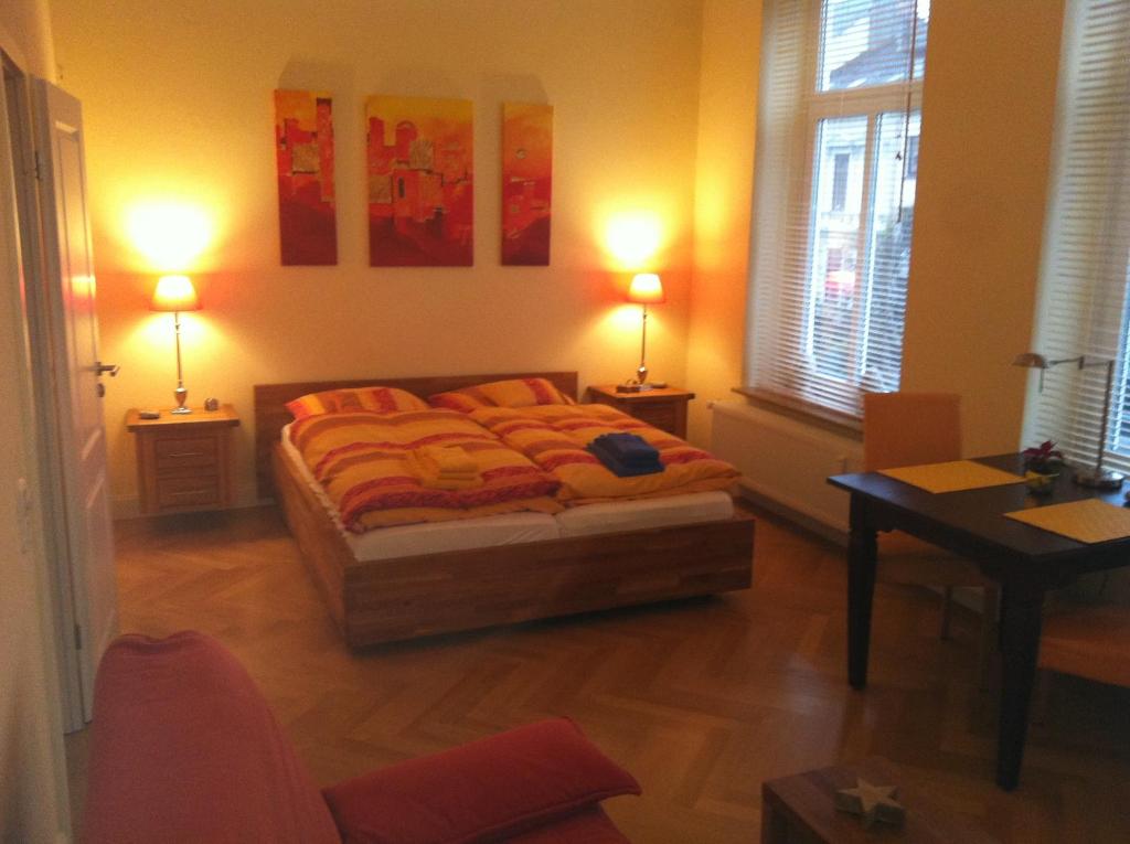 ein Schlafzimmer mit einem Bett mit zwei Lampen und einem Tisch in der Unterkunft Business Gästehaus Sonne, Mond & Sterne in Bremen