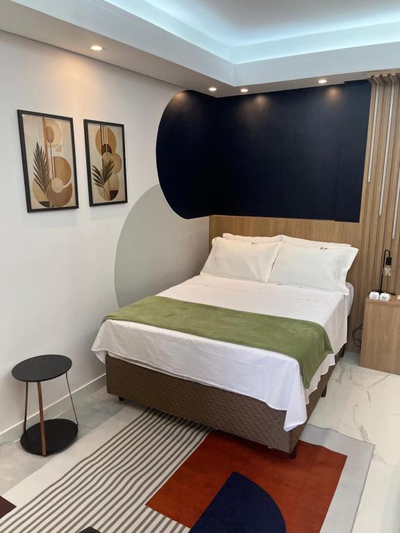 a bedroom with a large bed with a black headboard at Suíte Horto in Ouro Preto