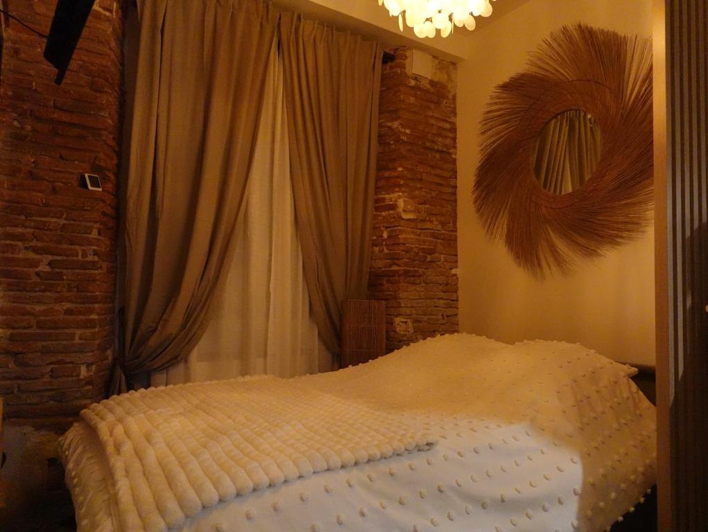 a bed in a room with curtains and a bed sidx sidx sidx at Le Petit Hôtel de Laura Cosy Parking & Netflix in Toulouse