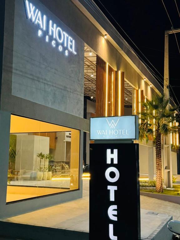 a hotel sign in front of a building at Wai Hotel Picos in Picos