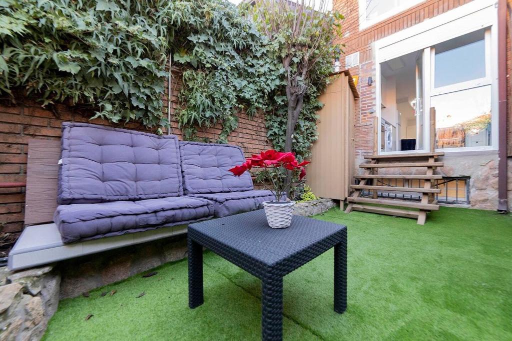a purple couch sitting on a patio with a table at Apartamento con jardín privado in Coslada