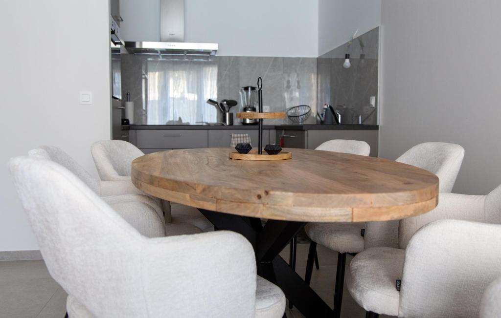 a dining room with a wooden table and white chairs at Machelen in Machelen