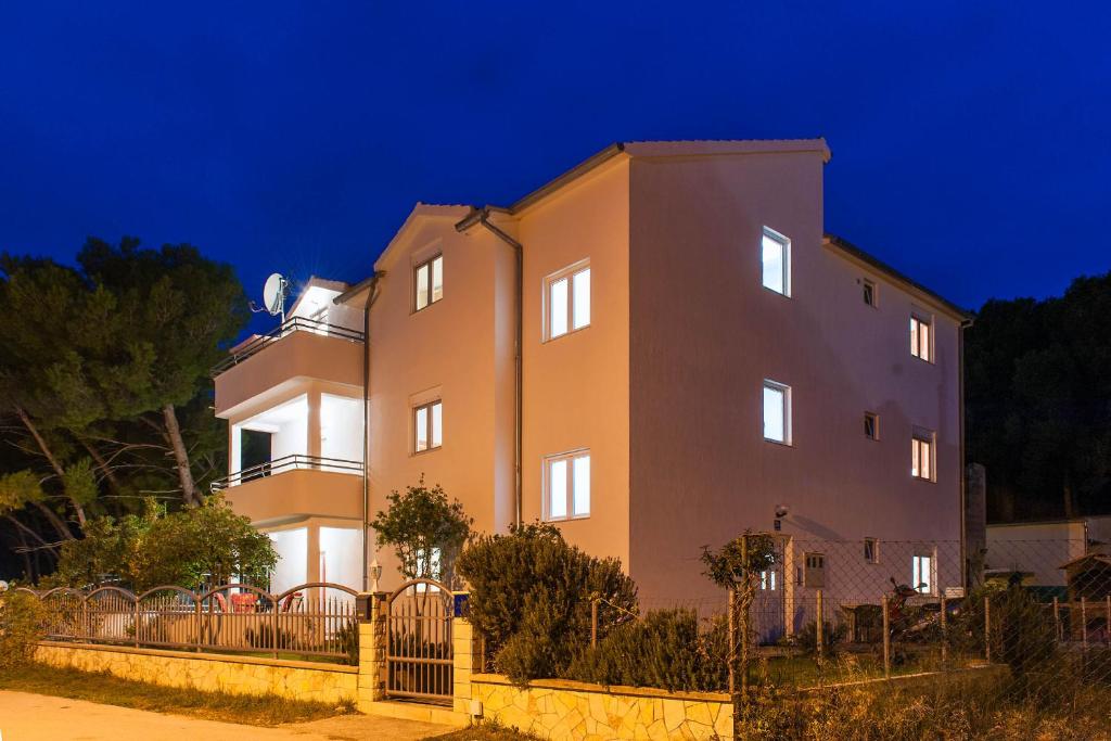 a building with a fence in front of it at night at Apartments Maras in Šibenik