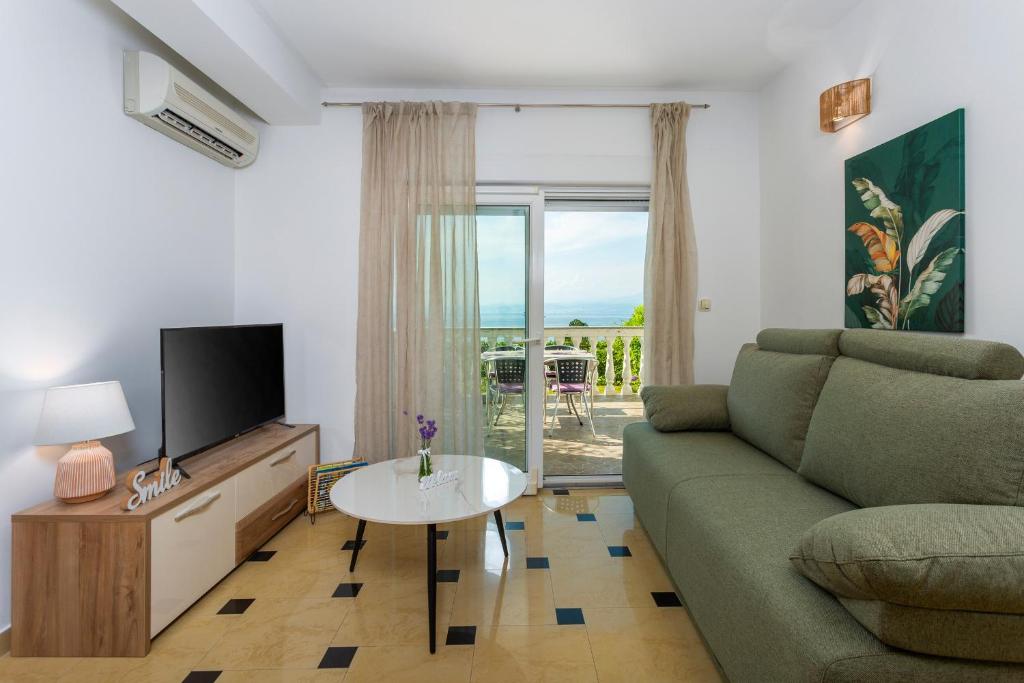 salon z kanapą, telewizorem i stołem w obiekcie Apartment Njivice 5295b w mieście Nijvice