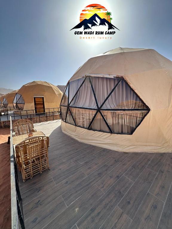 ein Zelt auf einer Terrasse mit Tischen und Stühlen in der Unterkunft Gem wadi rum camp in Wadi Rum