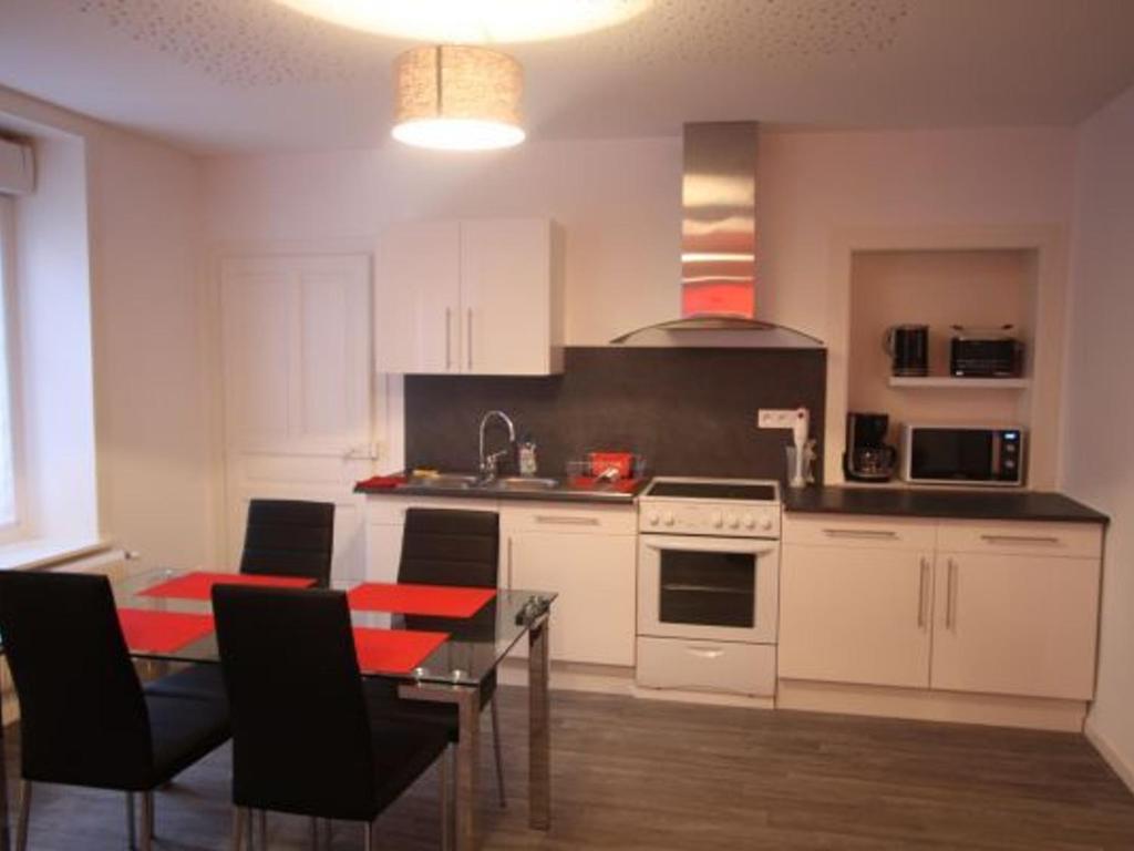 a kitchen with white cabinets and a table with a dining room at Appartement Rénové, Proche Centre-Ville Épinal, 2 Chambres, Confort, WiFi, Parking - FR-1-589-54 in Épinal