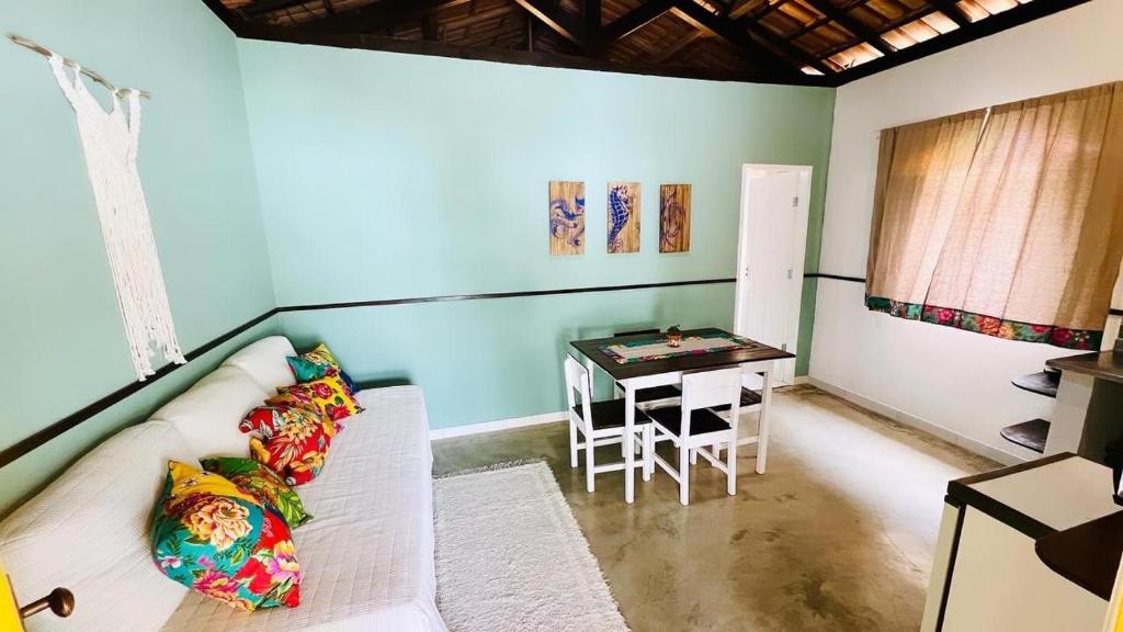 a living room with a couch and a table at Suítes e Chalé Colibri - Passarim Hospedagem in Cumuruxatiba
