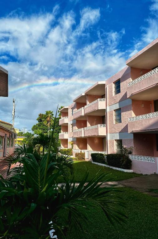 a large apartment building with palm trees in front of it at The Monteray Hotel in Christ Church
