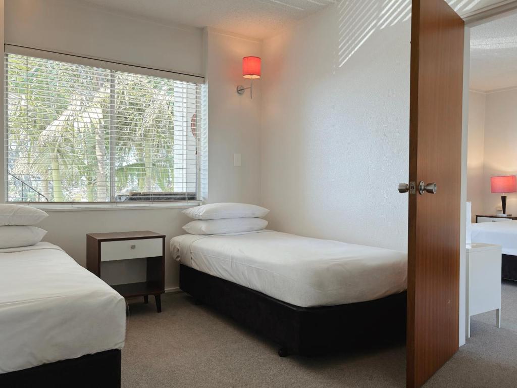 a bedroom with two beds and a window at Mt Albert Motor Lodge in Auckland