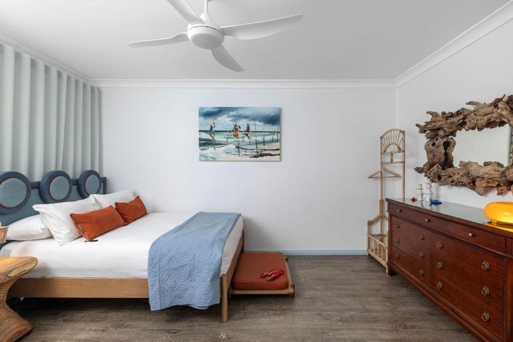 een slaapkamer met een bed en een plafondventilator bij Amadiya Marina Nelson Bay in Nelson Bay