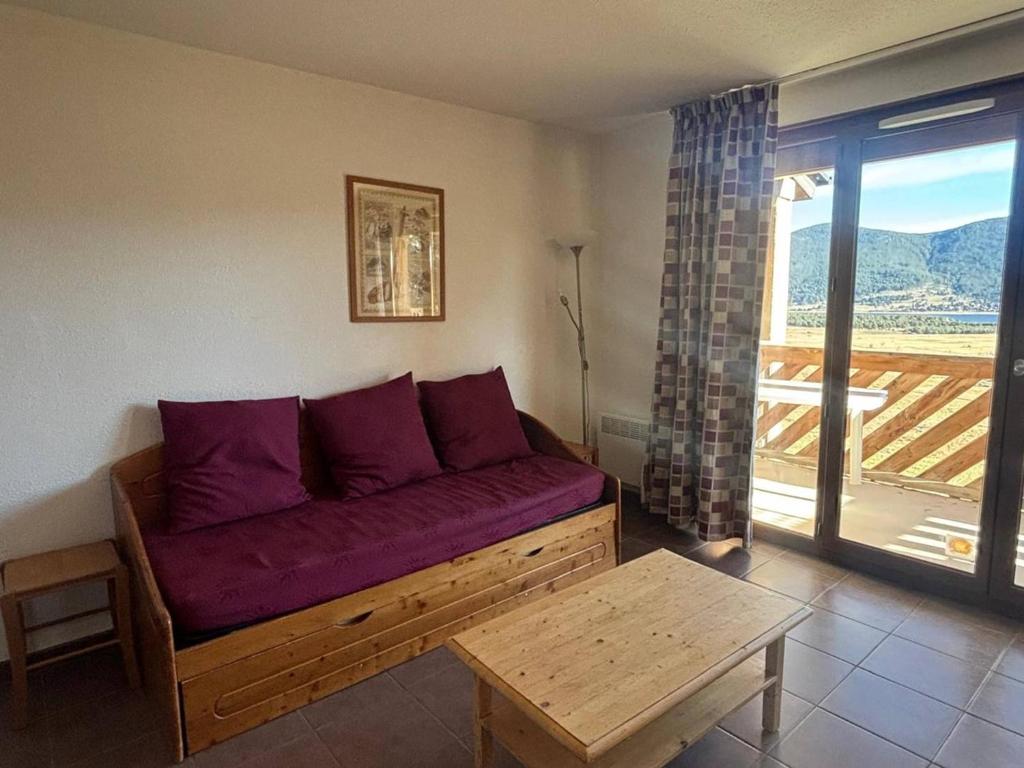un salon avec un canapé violet et une table dans l'établissement Appartement 3 pièces calme avec parking et balcon, Les Angles - FR-1-593-125, aux Angles