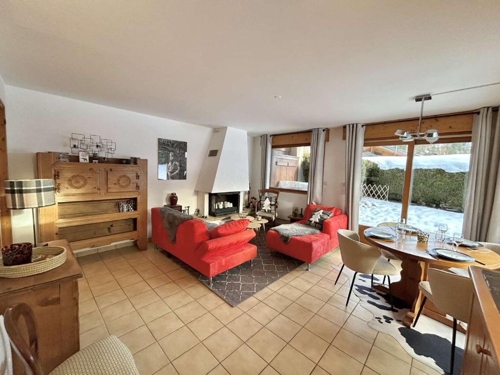 - un salon doté d'un mobilier rouge et d'une table dans l'établissement Charmant appartement 3 pièces, jardin, parking et wifi à Demi-Quartier - FR-1-597-187, à Demi-Quartier